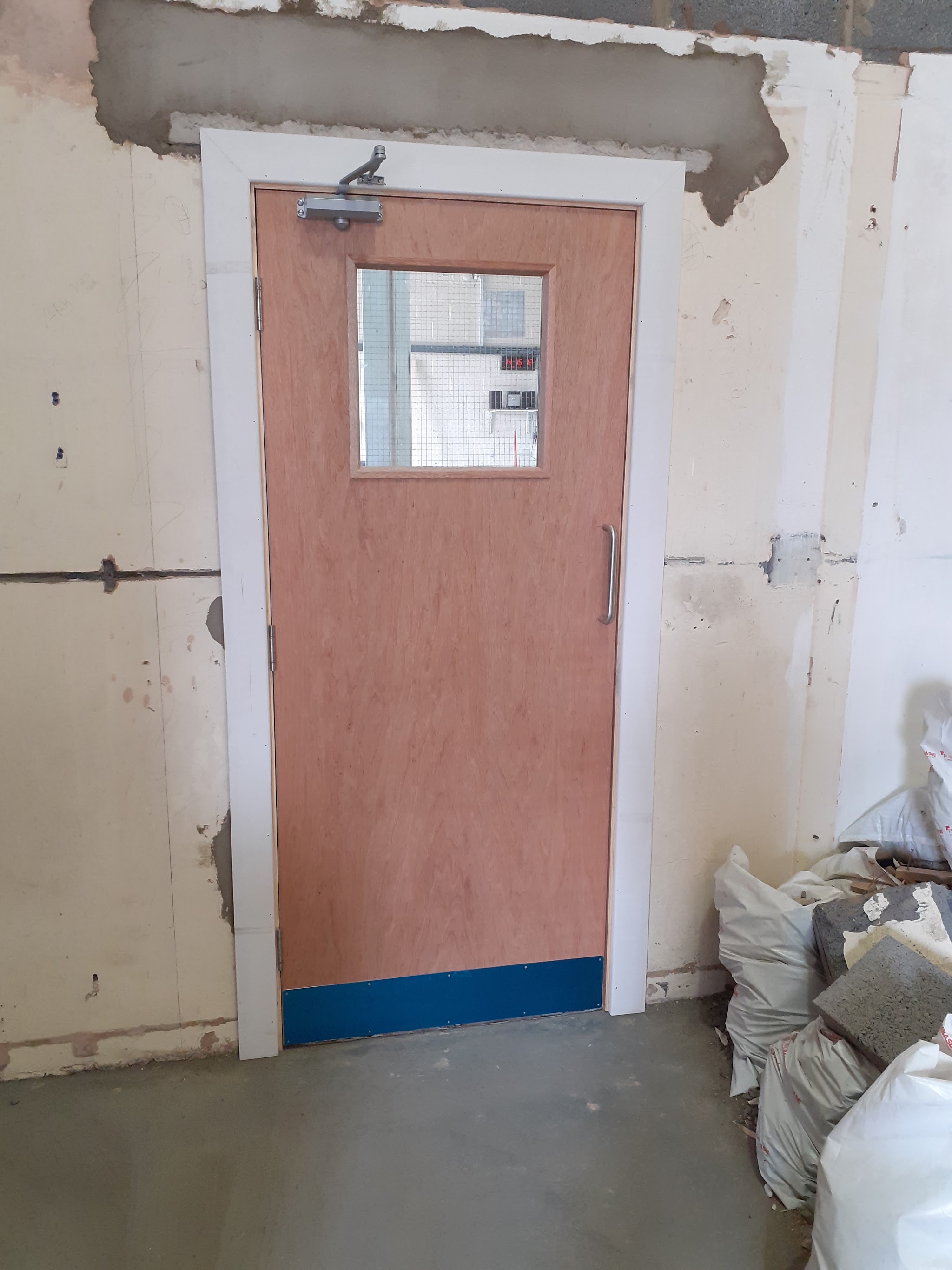 Hardwood door with a vision panel, closer and kick plate, newly fitted